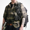 Person wearing a tactical harness with communication equipment and a backpack, showcasing utility gear and style.